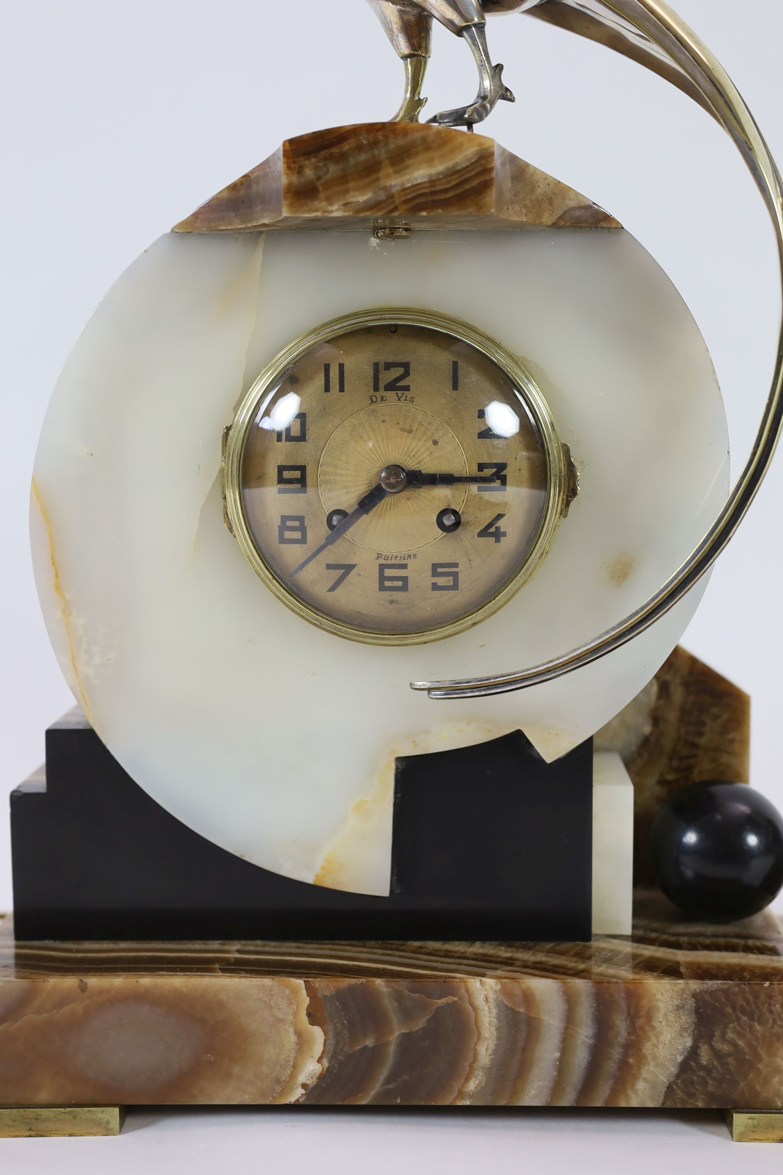 F.H. Danvin. A 1930's French Art Deco bronze mounted onyx and marble clock garniture, clock: width 32cm, height 46cm, side ornaments: width 15cm, height 31cm